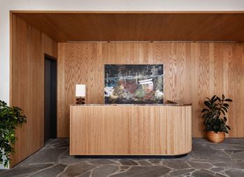 a wooden reception desk with a painting on the wall